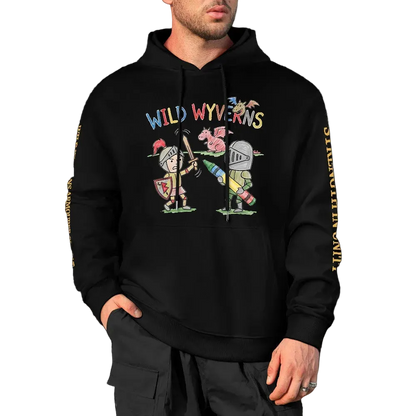 A man wearing a black pullover hoodie with a colorful graphic of two cartoon knights and the text 'WILD WYVERNS' across the chest, plus yellow text down both sleeves, shown against a black background.